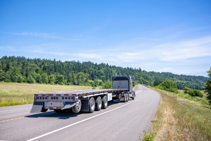 flatbed tractor trailer driving open Canadian Road